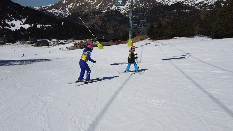 Guia i esquiador amb discapacitat visual baixant junts per la pista